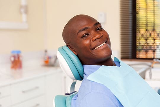 photo of happy smiling man in endodontic chair